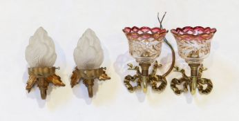 A pair of 1920s brass wall lights with frosted flame glass shades and a pair of brass ribbon back