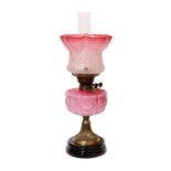 A late Victorian brass and pink opaque glass oil lamp with tinted frosted shade, height overall