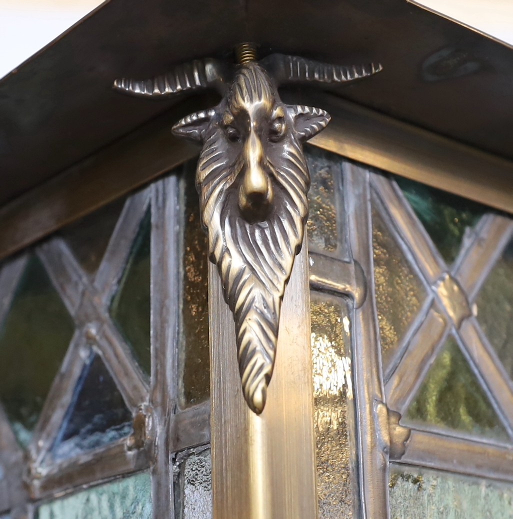 A large Edwardian lacquered brass and leaded glass hall lantern applied with rams head motifs, - Image 2 of 4