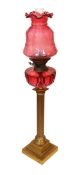 A Victorian lacquered brass fluted column oil lamp with cut ruby glass reservoir, Hinks No2