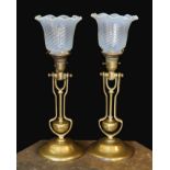 A pair of brass Pullman lamps with gimbal stems and Vaseline glass shades, modelled for wall