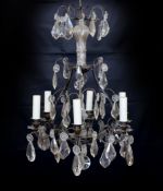 An early 20th century French bronze and cut glass six light chandelier hung with tear shaped and