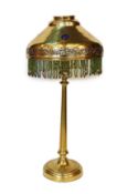 An early 20th century English brass table lamp, the jewelled shade with glass bead fringe, height