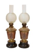 A pair of Victorian copper and brass oil lamps with aesthetic style floral decoration, black