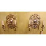 A pair of 17th century style silver plated wall lights with cherub and flower back plates and scroll