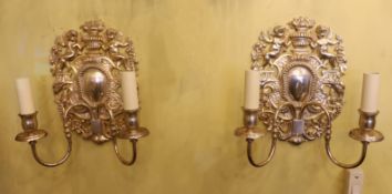 A pair of 17th century style silver plated wall lights with cherub and flower back plates and scroll