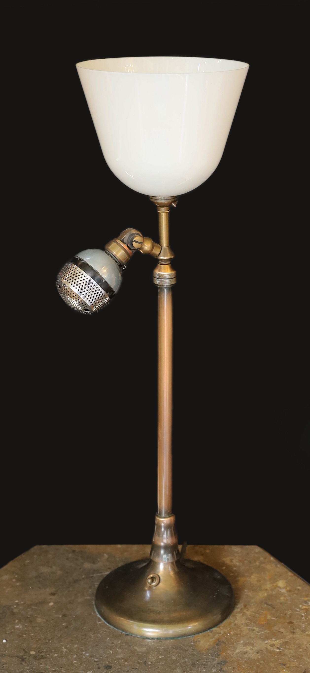 A 1920s BBC microphone converted to a table lamp, with loaded brass base and opaque white glass up