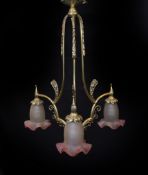 A 1930s French brass three light chandelier with cranberry tinted frosted glass shades, height 70cm.