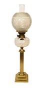 An Edwardian brass oil lamp with lobed glass reservoir, frosted globe and flue, height overall