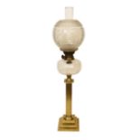 An Edwardian brass oil lamp with lobed glass reservoir, frosted globe and flue, height overall