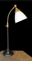 A 1930s English brass wrought iron and cast iron adjustable desk lamp with moulded opaque glass