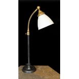 A 1930s English brass wrought iron and cast iron adjustable desk lamp with moulded opaque glass