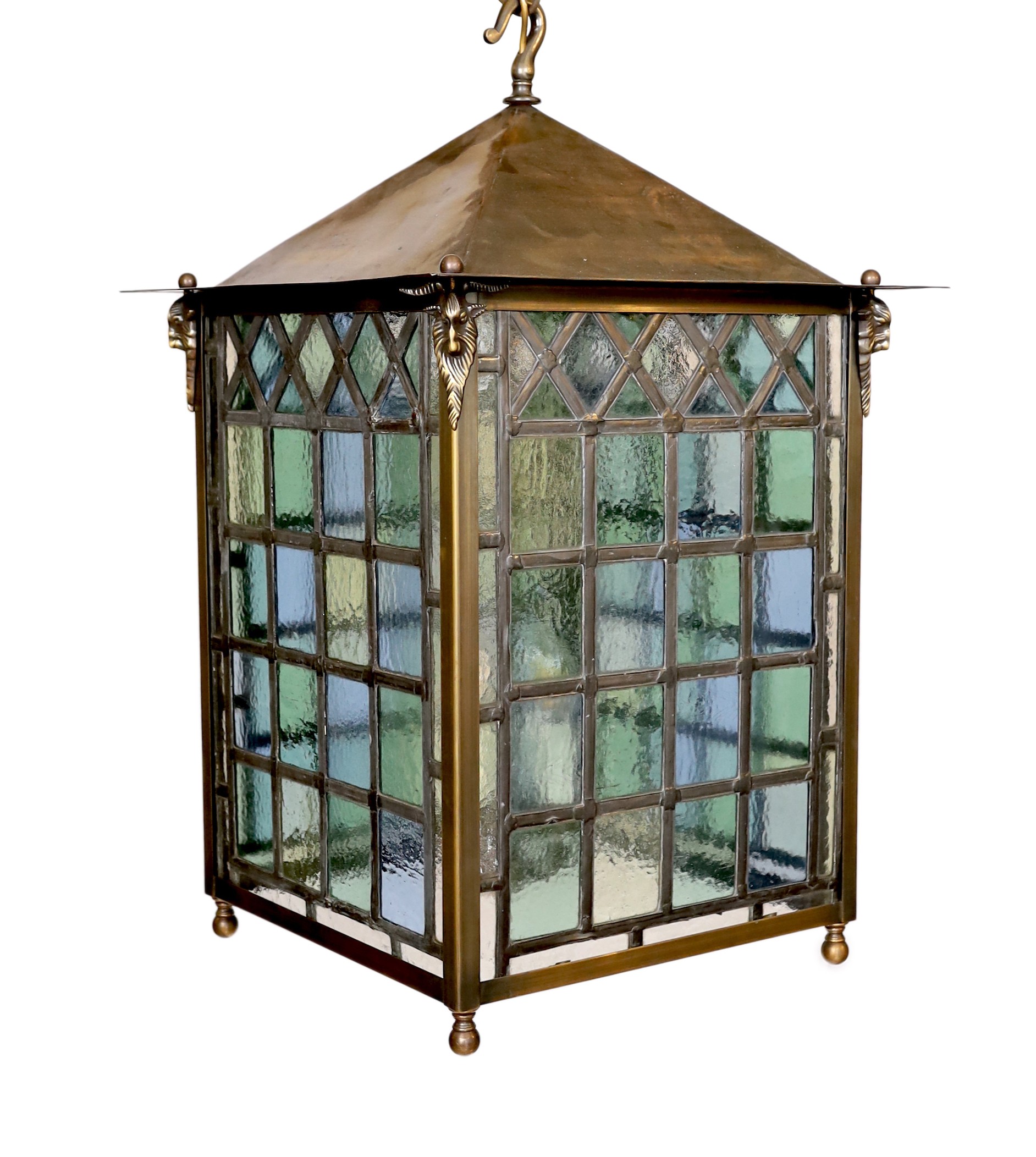 A large Edwardian lacquered brass and leaded glass hall lantern applied with rams head motifs,