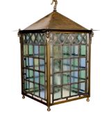 A large Edwardian lacquered brass and leaded glass hall lantern applied with rams head motifs,