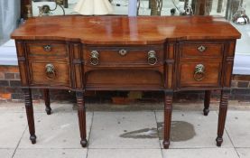 A Regency ebony strung mahogany breakfront sideboard, each deep drawer with ‘secret’ revolving