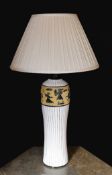 A 20th century Continental tinglazed pottery table lamp, decorated within a band of horse riders and