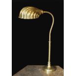 A 1930s English brass adjustable desk lamp, with flexible stem and scalloped shaped shade, height
