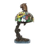 A bronze, stained glass and marble table lamp modelled as a flowering tree with parrot head,