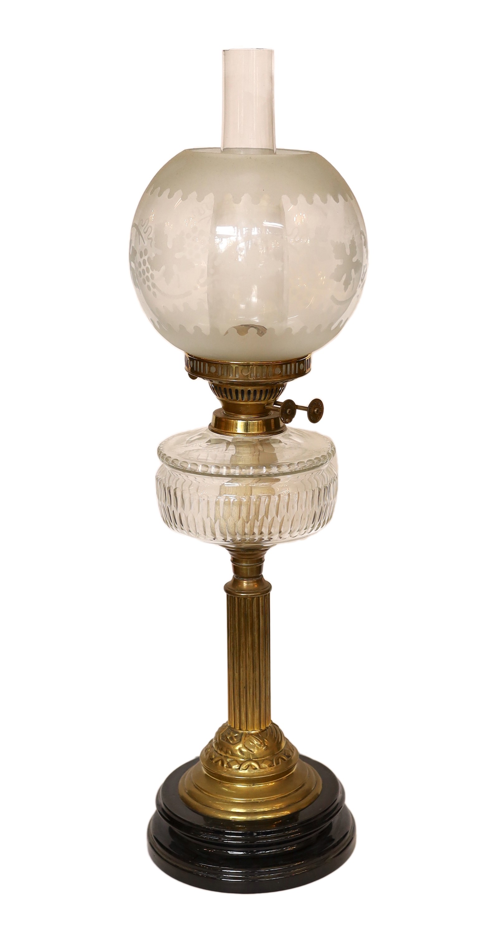 A late Victorian brass oil lamp with cut glass reservoir, duplex mechanism, etched glass globe and