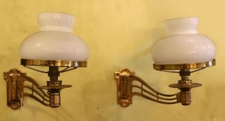 A pair of late Victorian brass swivelling wall lights with opaque glass shades, height 25cm. depth