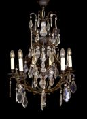 A French style patinated brass and cut glass eight light chandelier on with lozenge drops, drop