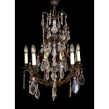 A French style patinated brass and cut glass eight light chandelier on with lozenge drops, drop