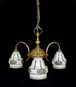 An early 20th century English lacquered brass light fitting with three stencilled opaque glass