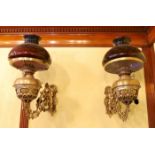 A pair of Victorian brass wall mounted oil lamps, with swivelling foliate pierced branches and