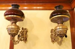 A pair of Victorian brass wall mounted oil lamps, with swivelling foliate pierced branches and