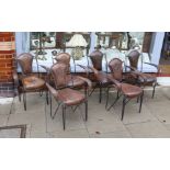 A set of six French wrought iron and brown leather elbow chairs, with brass ball finials, four