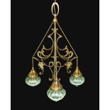 An English Arts & Crafts brass light fitting with scrolling foliate branches and tinted iridescent