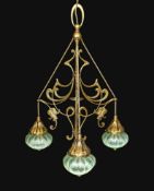An English Arts & Crafts brass light fitting with scrolling foliate branches and tinted iridescent