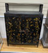 A late 19th century black painted decalomania decorated two door cupboard, width 92cm, depth 36cm,