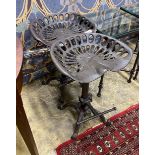 A pair of cast iron tractor seat stools, width 46cm, height 65cm