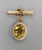 An early 20th century yellow metal, citrine and split pearl set oval pendant, overall 33mm, on a