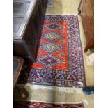 A Caucasian style red ground wool rug 184cms x 126cms.