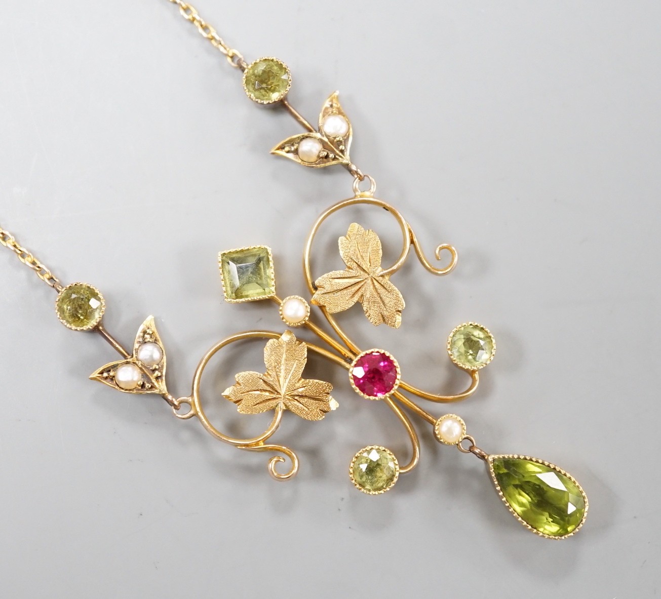 An Edwardian 15ct, peridot, seed pearl and ruby set drop pendant necklace, 46cm, gross weight 6.9