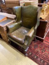 A George III style mahogany and olive green leather upholstered wing armchair, width 79cm, depth