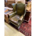 A George III style mahogany and olive green leather upholstered wing armchair, width 79cm, depth