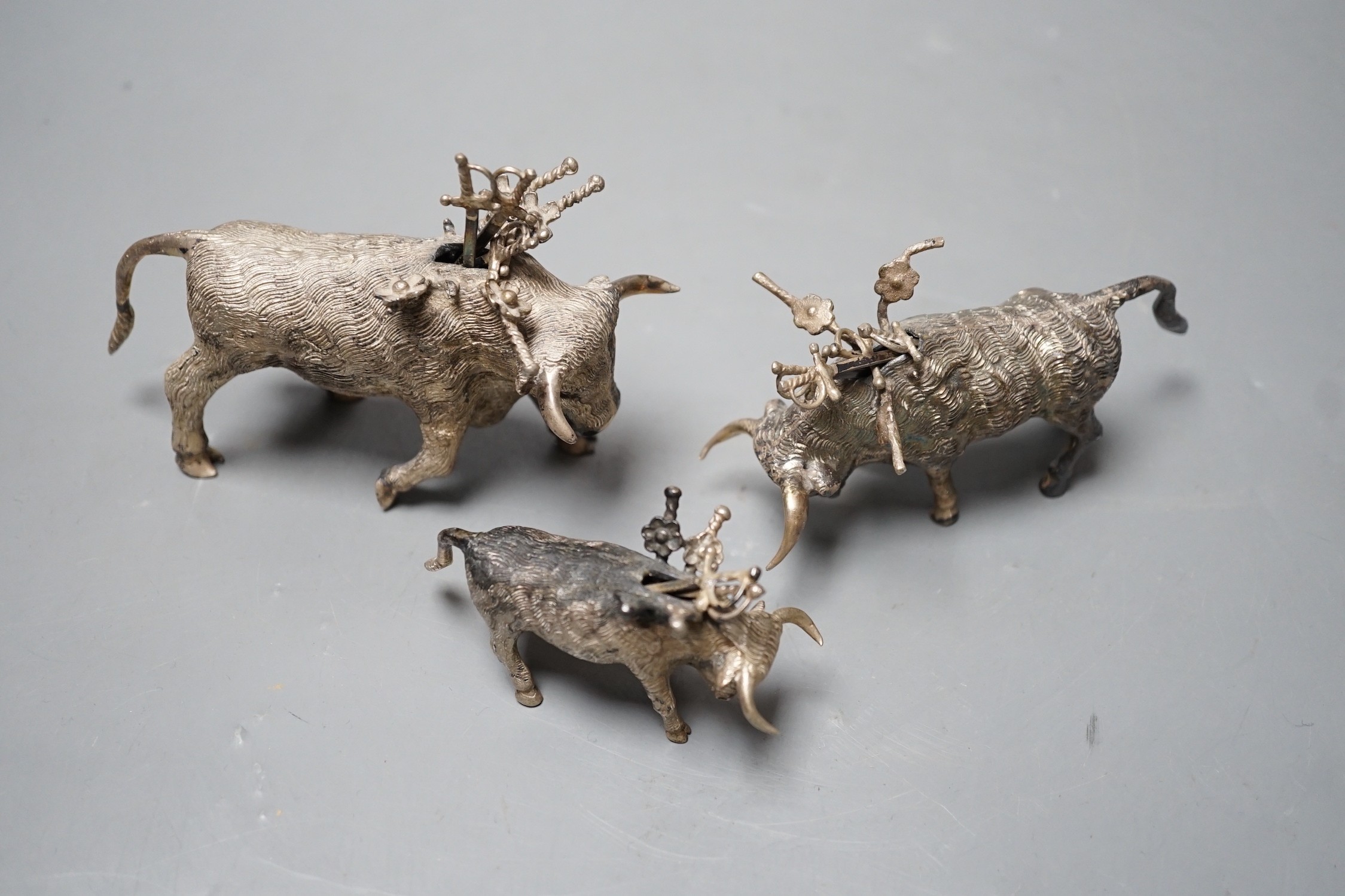 Three miniature white metal model cocktail stick holders? each modelled as a bull with sword - Image 3 of 3