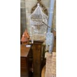 A stained pine pedestal with wirework bird cage, total height 174cm