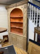 An early 18th century stripped pine alcove standing corner cupboard, width 154cm, depth 48cm, height