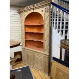 An early 18th century stripped pine alcove standing corner cupboard, width 154cm, depth 48cm, height