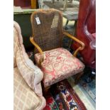 A 1920's upholstered walnut caned elbow chair, width 53cm, depth 48cm, height 88cm