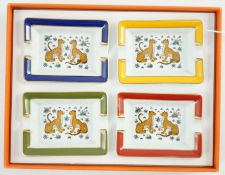 A boxed set of four Hermes porcelain ashtrays decorated with leopards, 8 cm.