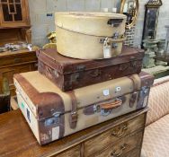 A leather and canvas covered suitcase, a small brown leather suitcase and hatbox, largest width