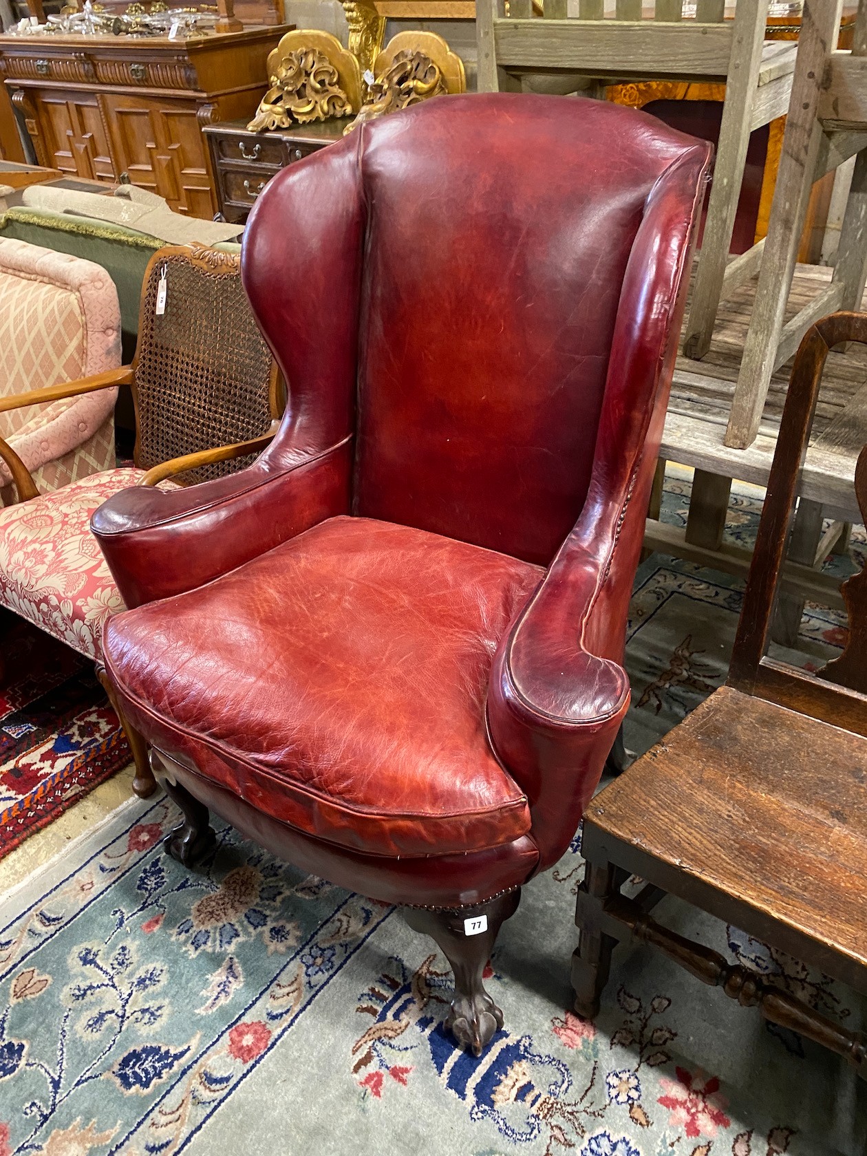 A George III style mahogany red leather upholstered wing armchair, width 91cm, depth 60cm, height