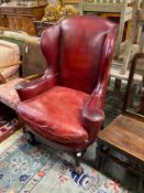 A George III style mahogany red leather upholstered wing armchair, width 91cm, depth 60cm, height