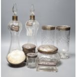 A collection of silver mounted glass items, including a pair of waisted decanters with two silver