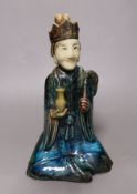 A 19th century Chinese flambé glazed seated figure of an immortal, 25cm